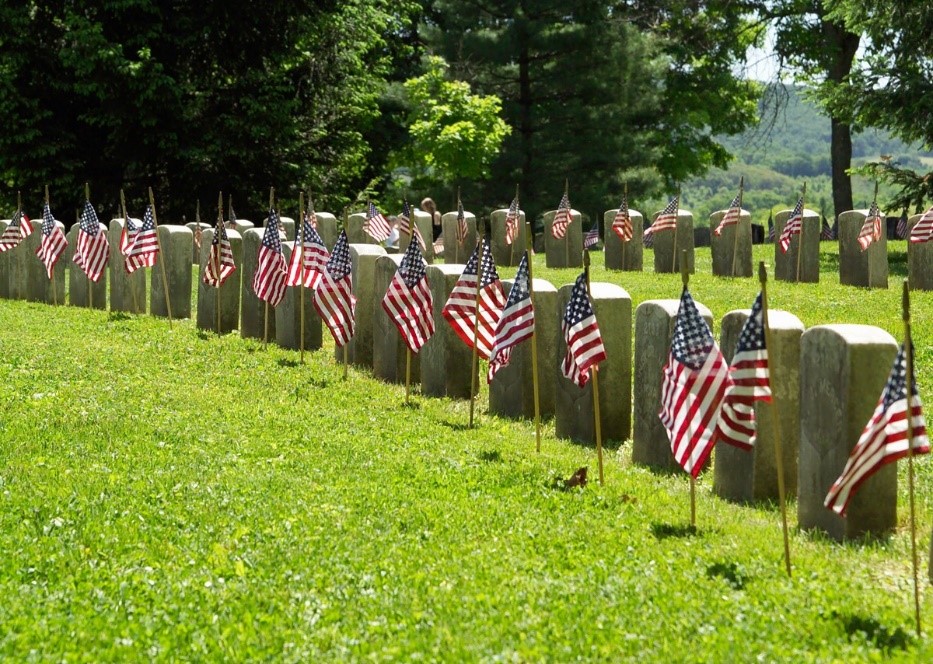 Memorial Day Genealogy by popular US online genealogists, Price Genealogy: image of headstones with American flags in front of them. 